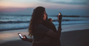 Couple hugging on the beach after understanding Cafcass section 7 report.