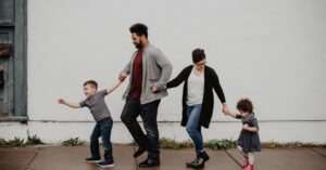 A family of four walks in a line, embodying their co-parenting agreement.