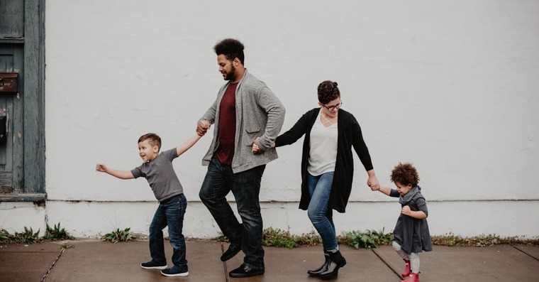 A family of four walks in a line, embodying their co-parenting agreement.